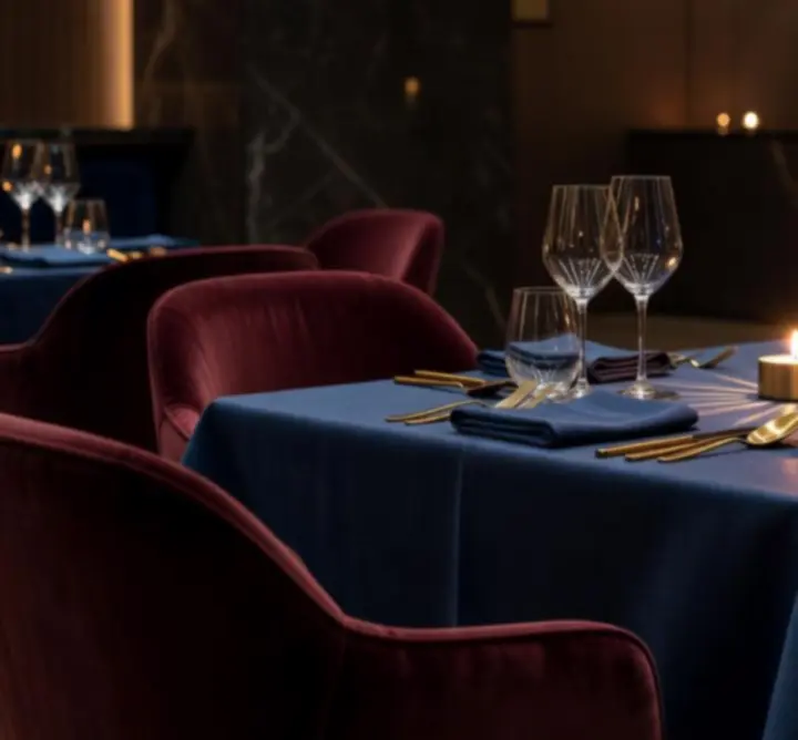Elegant table setting with velvet chairs, candles, and gold accents at Funteria Crown Dining